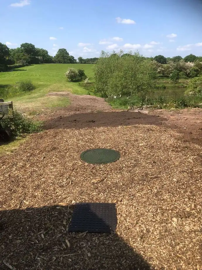 Finished ground with bark laid and an access cover left clear