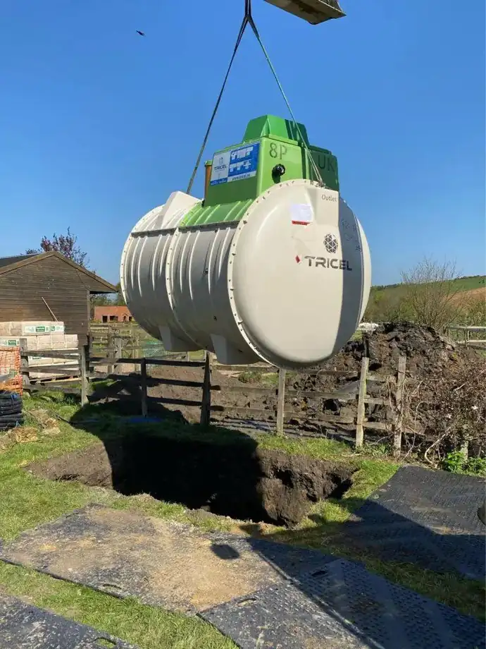 A sewage treatment plant being lifted into position by crane